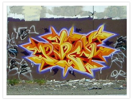 A vibrant graffiti mural featuring stylized lettering in shades of yellow and orange, with a purple outline, on a wall covered with additional tags and street art.