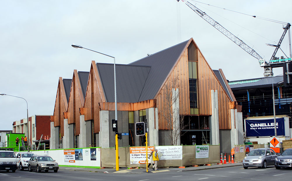 Image of Knox Church under reconstruction, featuring an architectural design with distinctive angled roofs and a mix of materials, located at the corner of Bealey Avenue and Victoria Street.