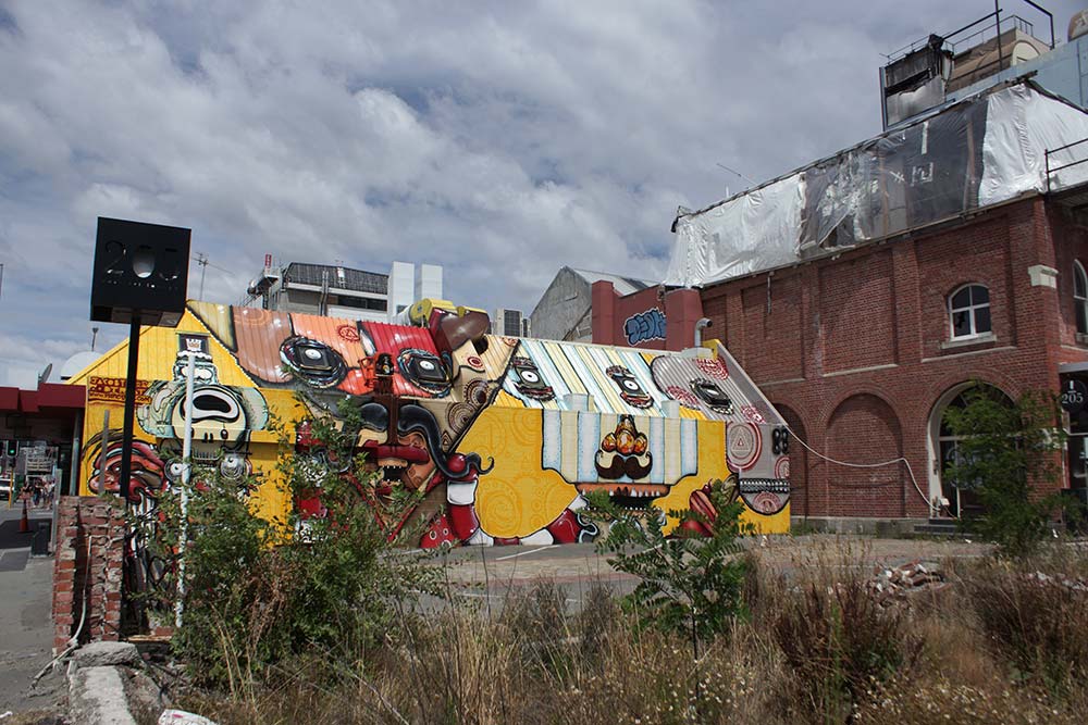 Bright mural on the side of a building featuring colorful Mexican characters, painted by artist Jacob Yikes. The mural adds character to the new Mexican restaurant called Mexico, located at the corner of Hereford and Manchester Streets.